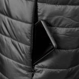 A black puffer vest with a smartphone partially tucked into a zippered pocket. The fabric features a quilted design.
