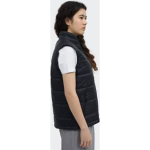 A women's puffer vest in black, featuring a collar and a side view of the model wearing it. It has a logo displayed.