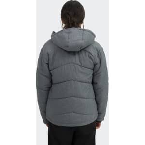 A women's puffer jacket in grey with a hood, featuring a chevron quilted design and a logo on the back.