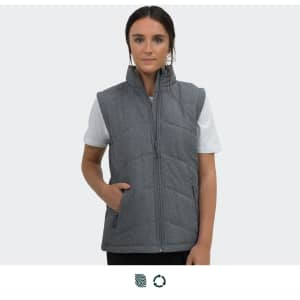 A grey puffer vest with a zip, featuring side pockets, worn by a model on a plain background.