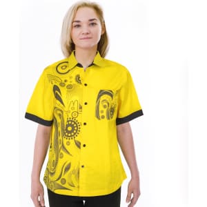 A vibrant yellow women's shirt featuring a black patterned design and contrasting black cuffs. The shirt has a logo.