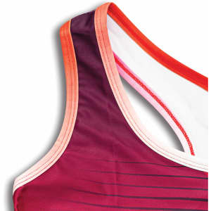 A custom women's athletics crop top in shades of purple and red with a contrasting trim and a branding logo.