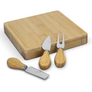 A square bamboo cheese board with three cheese utensils featuring bamboo handles and stainless steel blades.