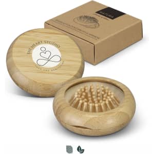 A bamboo brush and mirror set in a natural wood finish, presented in a brown cardboard box with a logo.