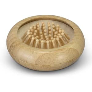 A bamboo brush with a rounded base and numerous bristles, accompanied by a mirror, showcasing natural tones.