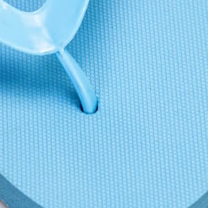 A close-up of a light blue Tidal Flip Flop with a thong strap and textured footbed. Features a logo.