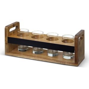 A wooden taster tray in natural hues with a black centre section, featuring four glass cups set in circular holders.