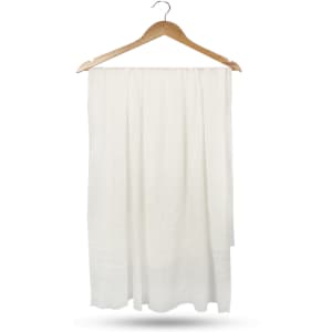 A white compressed towel hanging on a wooden hanger, featuring a textured surface and a simple design.