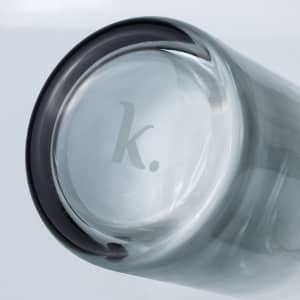 A glass carafe with a dark rim and a logo at the base, showcasing a sleek and modern design.