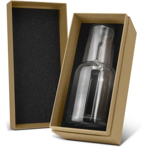 A glass carafe and tumbler set in a brown box with black interior padding. The glass is clear and sleek.