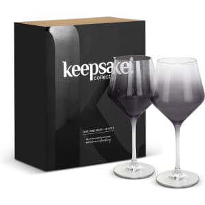 A set of two gradient purple wine glasses with stems, packaged in a sleek black box featuring a logo.