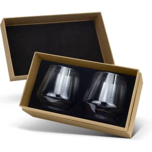 A gift box containing two clear, dark-coloured whiskey glasses with a sleek, modern design.