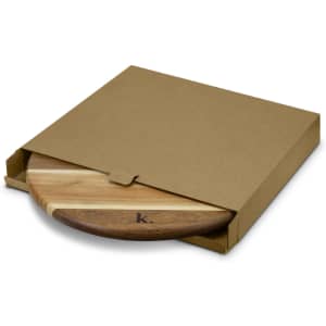 A wooden Lazy Susan featuring a mix of light and dark wood tones, presented in a simple brown cardboard box.