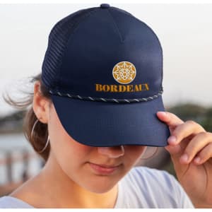 A navy trucker cap featuring a logo on the front and a decorative edge on the brim.