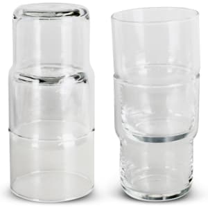 A set of clear glass tumblers stacked together, featuring a sleek and modern design. Each tumbler has a smooth finish.