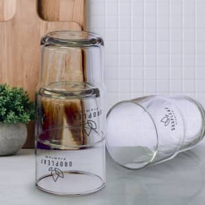 A stack of transparent glass tumblers in a modern design, featuring a logo on the side.