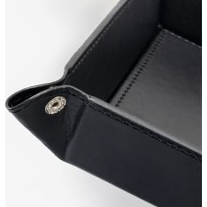 A black leather valet tray with stitched detailing and decorative fasteners at the corners.