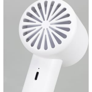 A white personal cooling fan featuring a circular grill design, with a charging port at the base.