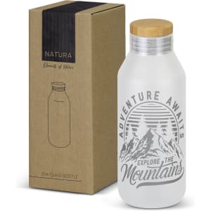 A drink bottle with a frosted glass finish, wooden lid, and mountain-themed design, accompanied by a cardboard box.