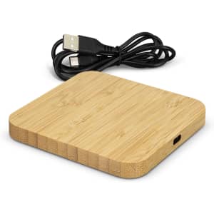 A bamboo wireless charging hub with a smooth surface and a USB cable attached.
