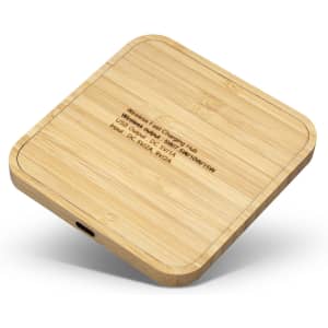 A bamboo wireless fast charging hub with a square design and a port on the side. It features a subtle logo on top.