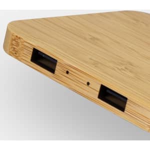 A bamboo wireless charging hub with a sleek design featuring multiple ports on one side.