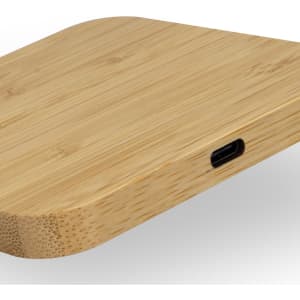 A bamboo wireless charging hub with a sleek, rounded design and a USB-C port.