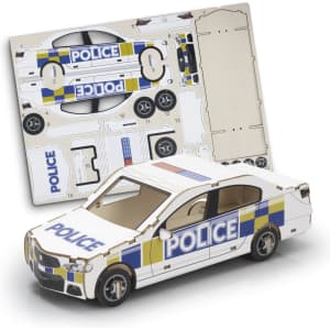 A model car in white with blue and yellow police markings, alongside its cardboard assembly sheet.