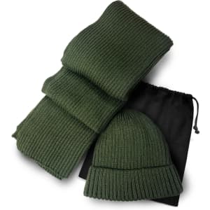 A green ribbed scarf and matching beanie set, neatly arranged with a black drawstring bag.