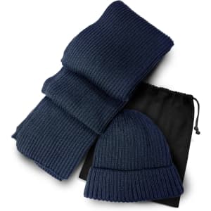 A navy ribbed scarf and beanie set, packaged with a black drawstring bag.