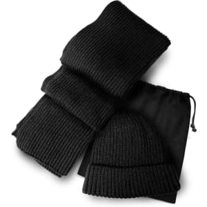 A black knitted scarf and beanie set, packaged with a drawstring bag. The scarf is folded neatly beside the beanie.