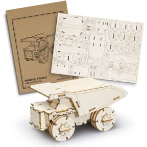 A wooden model of a mining truck in natural wood colour, with accompanying assembly sheets and a branded box.