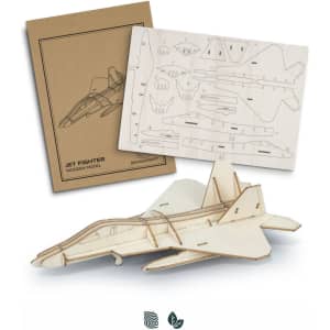 A wooden model of a jet fighter in natural wood tones, packaged with a template and parts for assembly.