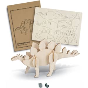A wooden model of a stegosaurus in natural wood colour, alongside pre-cut assembly sheets.