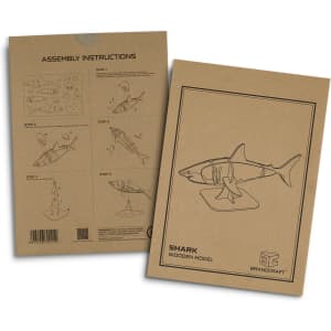An assembly instruction booklet for a wooden shark model, featuring line drawings and a neutral brown background.