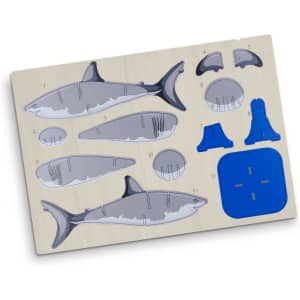 A wooden puzzle model of a shark, featuring grey and blue pieces on a light wooden base.