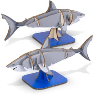 A model of a grey shark made from wood, displayed on a blue base, showcasing puzzle-like pieces.