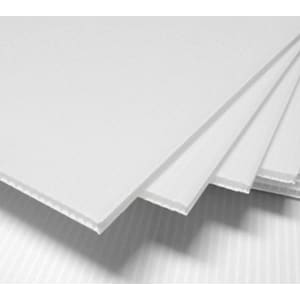 A stack of white core flute sheets with a ribbed texture, displaying multiple layers.