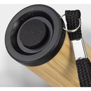A bamboo torch with a black top and a woven strap for attachment. It features a circular textured button.