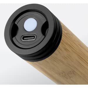 A bamboo torch featuring a USB-C charging port and a control button on the top. It has a sleek, natural wooden finish.