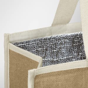 A jute cooler bag featuring a silver insulated interior and natural jute exterior with cream handles.