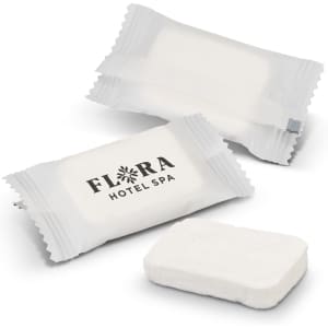 Compressed towels in white packaging, with an accompanying towel in a rectangular shape. One package features a logo.