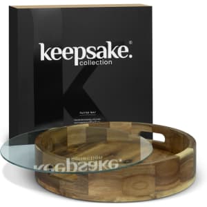 A wooden platter tray with a glass top, presented in a black branded box. The tray features a circular design.