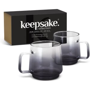 A set of two transparent grey coffee mugs in a black and brown box, featuring smooth handles.