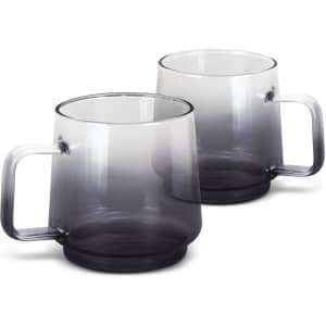 A set of two glass coffee mugs in a gradient of grey, featuring a sturdy handle and a smooth finish.