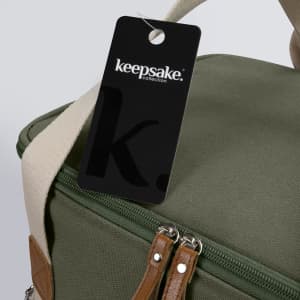 A green cooler bag with a zip closure and a tag featuring a logo. It has tan accents and a shoulder strap.