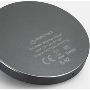 A circular grey wireless charger with a logo and output specifications on the base.