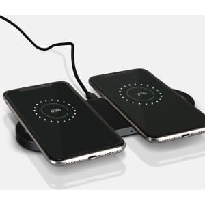 A sleek black dual wireless charger with two smartphones displaying charging indicators.