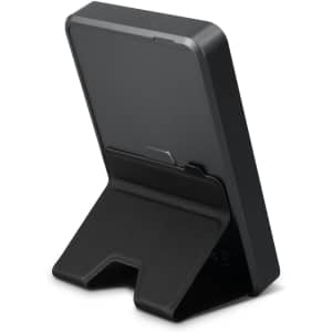 A black wireless charging power bank with a foldable stand for stability, featuring a logo on the back.