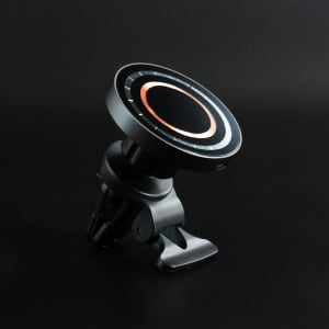 A black wireless car charger with a circular design and a clip mount. It features a ring of bronze accents.